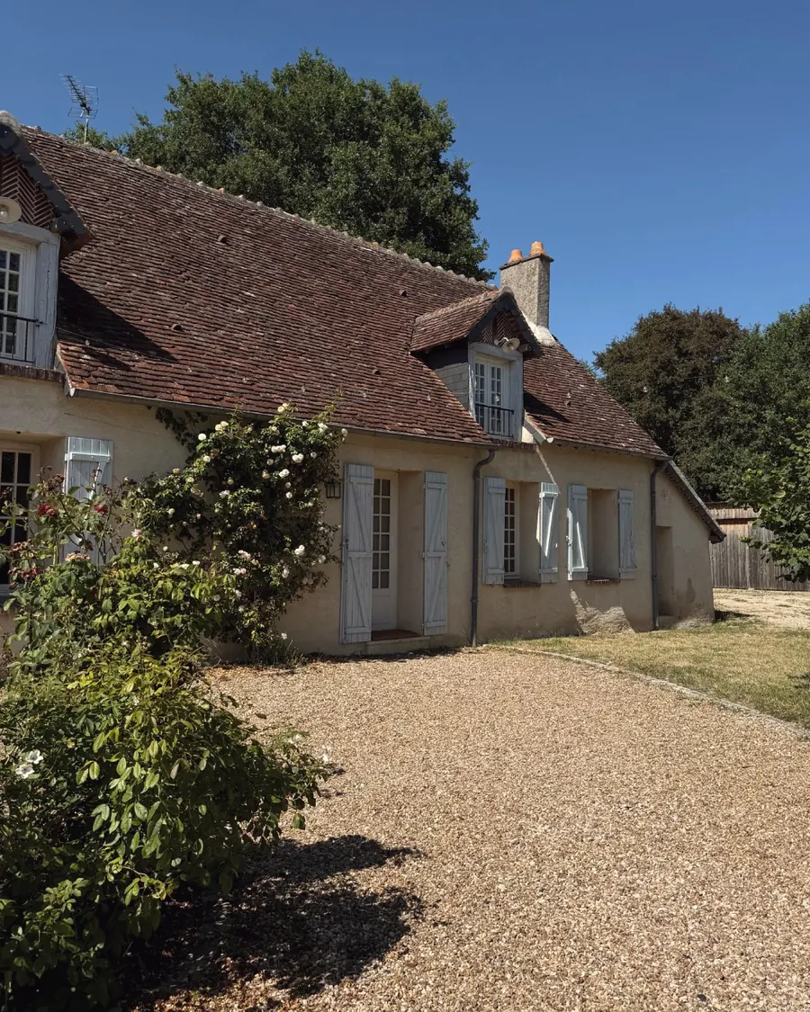 Le pignon de la maison et ses volets bleus, depuis l'allée
