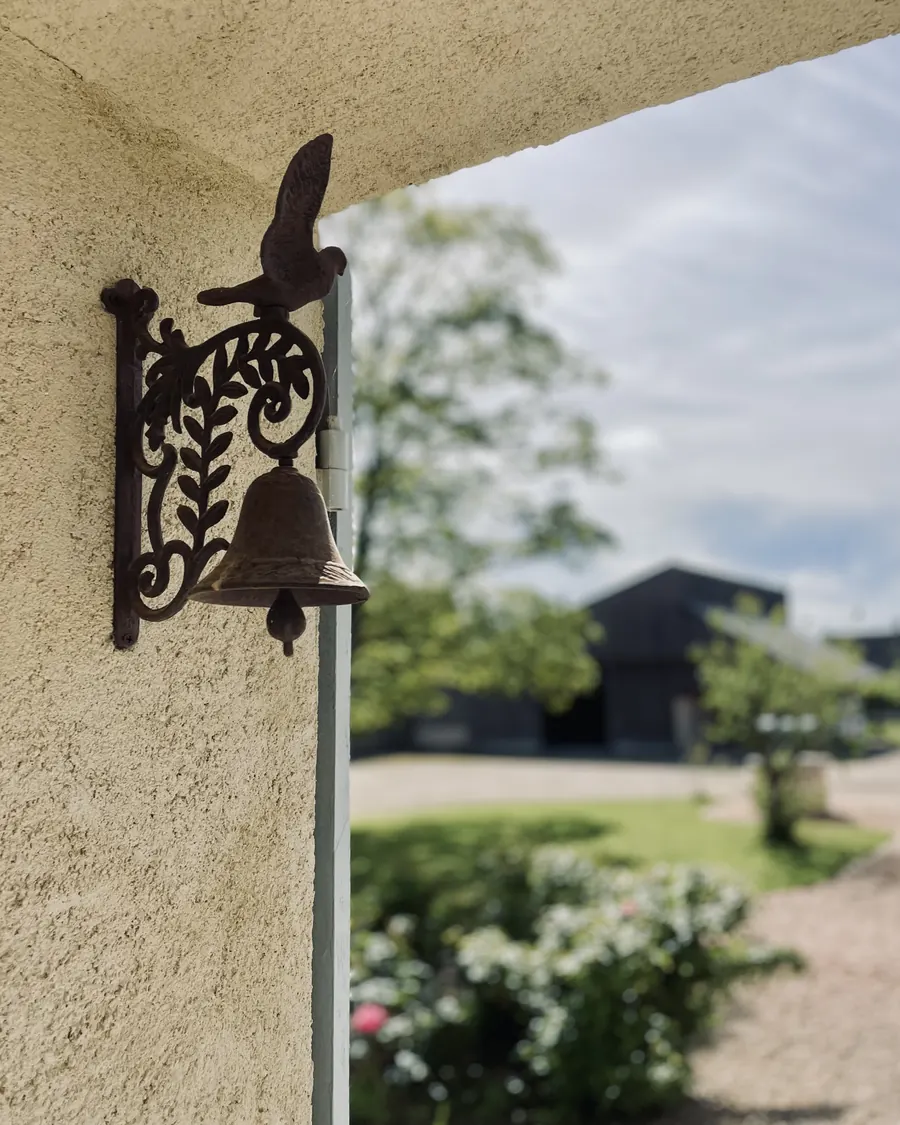 La cloche en fer forgé fixée au mur de tuffeau